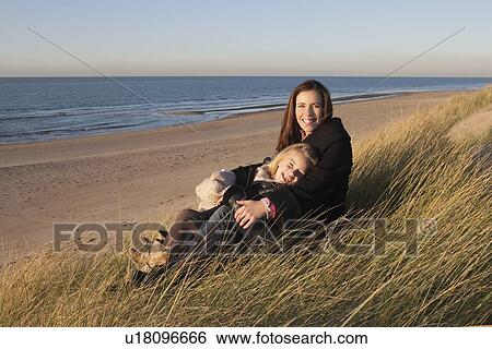 Stock Photograph - Netherlands, Zeeland, Haamstede, Mother with daughter on beach. Fotosearch