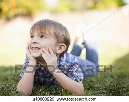 Stock Photograph - Outdoor portrait of happy young boy (6-7) . Fotosearch