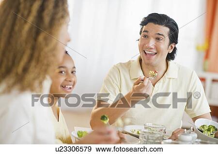 Parents with daughter (12-13) eating dinner View Large Photo Image Stock Photo - Parents with daughter (12-13) eating dinner. Fotosearch