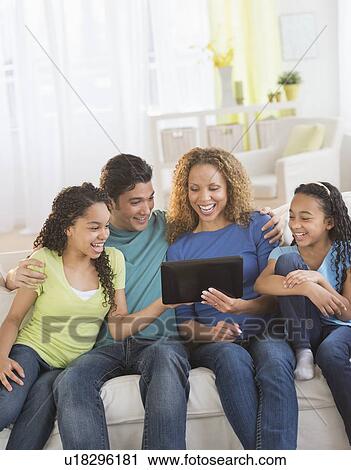 Stock Image - Parents with daughters (10-13) using tablet pc. Fotosearch