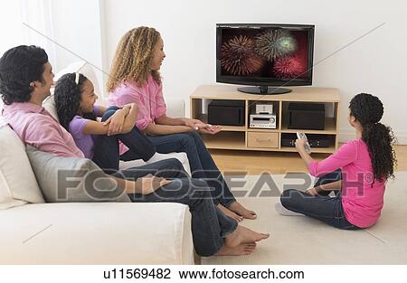 Parents with daughters (10-13) watching tv View Large Photo Image Stock Image - Parents with daughters (10-13) watching tv. Fotosearch