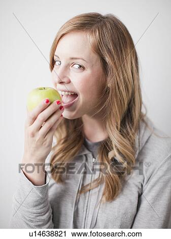 Portrait of attractive young woman holding green apple View Large Photo Image Stock Image - Portrait of attractive young woman holding green apple. Fotosearch