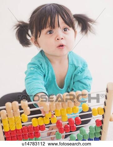 Portrait of baby girl (12-17 months) playing with abacus View Large Photo Image Stock Image - Portrait of baby girl (12-17 months) playing with abacus. Fotosearch