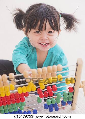 Portrait of baby girl (12-17 months) playing with abacus View Large Photo Image Stock Image - Portrait of baby girl (12-17 months) playing with abacus. Fotosearch