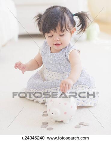 Portrait of baby girl (12-17 months) playing with piggy bank View Large Photo Image Stock Image - Portrait of baby girl (12-17 months) playing with piggy bank. Fotosearch