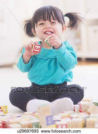 Portrait of baby girl (12-17 months) playing alphabet blocks View Large Photo Image Stock Image - Portrait of baby girl (12-17 months) playing alphabet blocks. Fotosearch