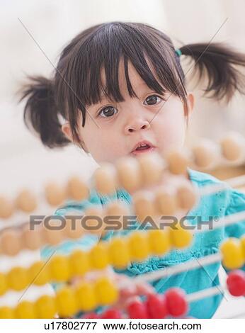Portrait of baby girl (12-17 months) playing with abacus View Large Photo Image Stock Photo - Portrait of baby girl (12-17 months) playing with abacus. Fotosearch