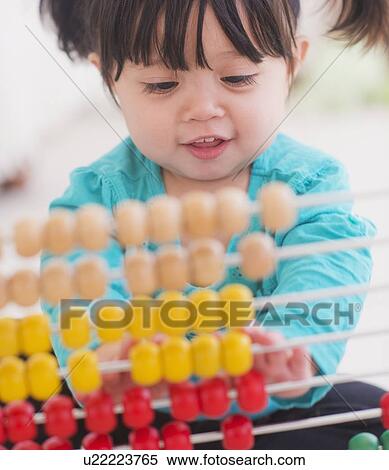 Portrait of baby girl (12-17 months) playing with abacus View Large Photo Image Stock Photography - Portrait of baby girl (12-17 months) playing with abacus. Fotosearch