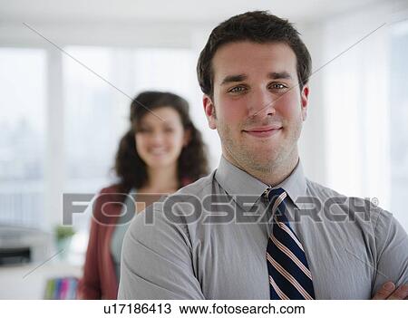 Portrait of business man, business woman in background View Large Photo Image Stock Image - Portrait of business man, business woman in background. Fotosearch