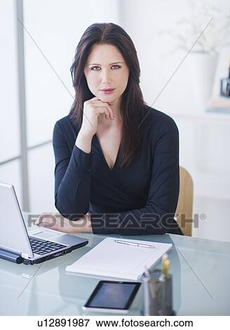 Stock Photo - Portrait of businesswoman at desk. Fotosearch