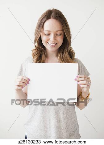 Portrait of cheerful young woman holding blank card View Large Photo Image Stock Image - Portrait of cheerful young woman holding blank card. Fotosearch