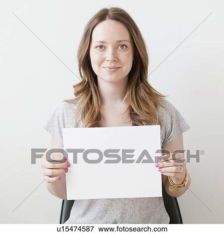 Portrait of cheerful young woman holding blank card View Large Photo Image Stock Photo - Portrait of cheerful young woman holding blank card. Fotosearch