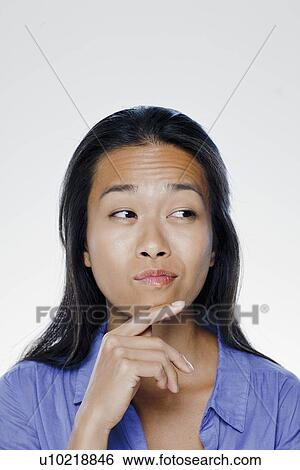 Portrait of confused young woman, studio shot View Large Photo Image Stock Photograph - Portrait of confused young woman, studio shot. Fotosearch