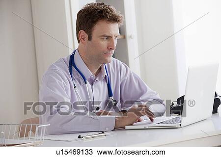 Portrait of doctor working on laptop View Large Photo Image Stock Image - Portrait of doctor working on laptop. Fotosearch