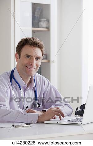 Portrait of doctor working on laptop View Large Photo Image Stock Photograph - Portrait of doctor working on laptop. Fotosearch