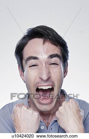 Stock Image - Portrait of excited man, studio shot. Fotosearch