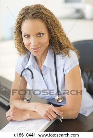 Portrait of female doctor at desk View Large Photo Image Stock Image - Portrait of female doctor at desk. Fotosearch