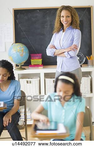 Portrait of female teacher in classroom with schoolgirls (10-13) View Large Photo Image Stock Photo - Portrait of female teacher in classroom with schoolgirls (10-13). Fotosearch