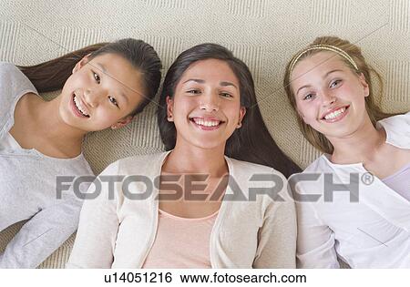 Portrait of friends (14-19) lying on floor View Large Photo Image Stock Photograph - Portrait of friends (14-19) lying on floor. Fotosearch