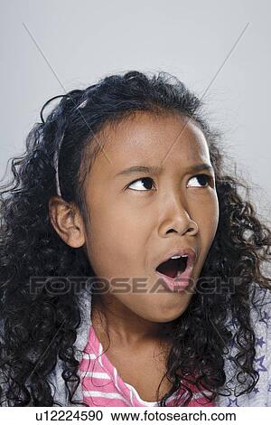 Stock Image - Portrait of girl (10-11), studio shot. Fotosearch