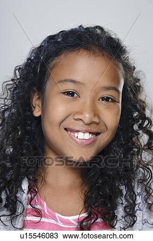 Stock Image - Portrait of girl (10-11), studio shot. Fotosearch
