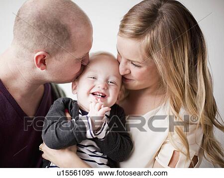 Stock Photography - Portrait of happy young family with baby boy (12-17 months). Fotosearch