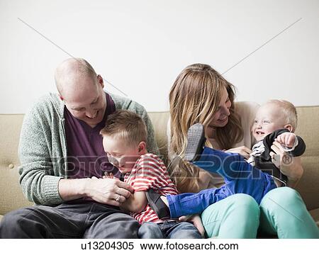 Stock Photography - Portrait of happy young family with two boys (12-17 months, 2-3). Fotosearch