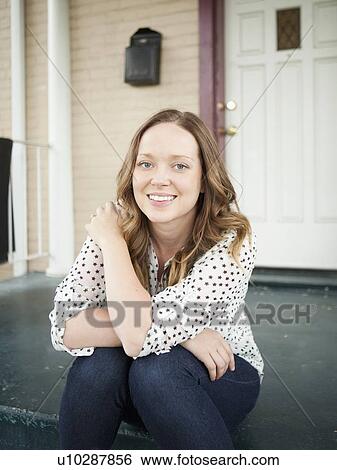 Portrait of happy young woman sitting on porch View Large Photo Image Stock Photograph - Portrait of happy young woman sitting on porch. Fotosearch