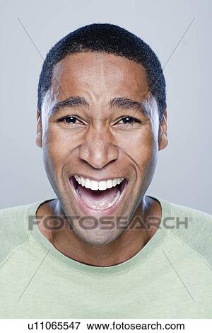 Portrait of laughing young man, studio shot View Large Photo Image Stock Photo - Portrait of laughing young man, studio shot. Fotosearch