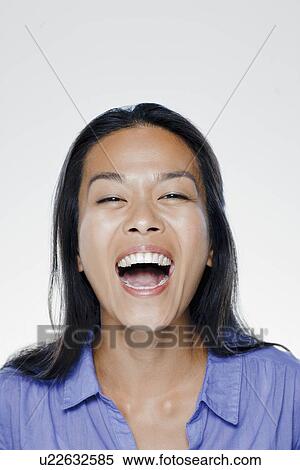 Stock Photography - Portrait of laughing young woman, studio shot. Fotosearch