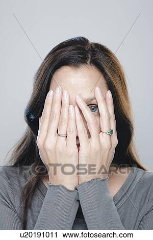 Stock Image - Portrait of mature woman, studio shot. Fotosearch