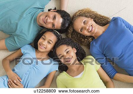 Portrait of parents with daughters (10-13) lying on floor View Large Photo Image Stock Photo - Portrait of parents with daughters (10-13) lying on floor. Fotosearch