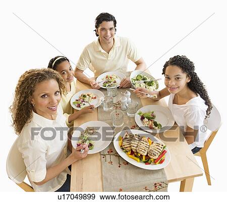 Portrait of parents with daughters (10-13) eating dinner View Large Photo Image Stock Photo - Portrait of parents with daughters (10-13) eating dinner. Fotosearch