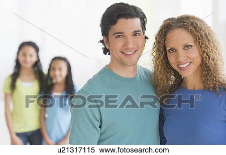 Stock Photography - Portrait of parents with daughters (10-13) in background. Fotosearch