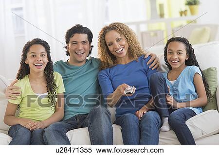 Portrait of parents with daughters (10-13) watching tv View Large Photo Image Stock Photography - Portrait of parents with daughters (10-13) watching tv. Fotosearch