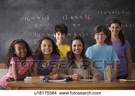 Picture - Portrait of pupils (10-11, 12-13) and teacher with blackboard in background. Fotosearch