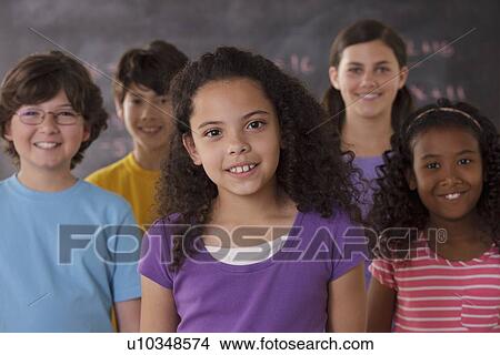 Picture - Portrait of pupils (10-11, 12-13) with blackboard in background. Fotosearch