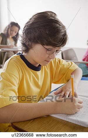 Stock Photo - Portrait of schoolboy (10-11) writing. Fotosearch