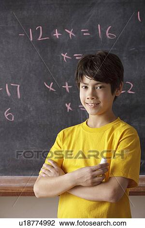 Portrait of schoolboy (12-13) standing in front of blackboard during math classes View Large Photo Image Stock Image - Portrait of schoolboy (12-13) standing in front of blackboard during math classes. Fotosearch