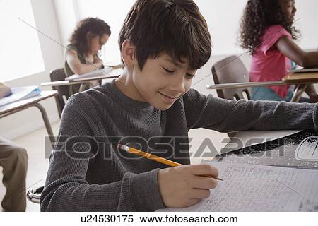 Stock Photography - Portrait of schoolboy (12-13) writing. Fotosearch