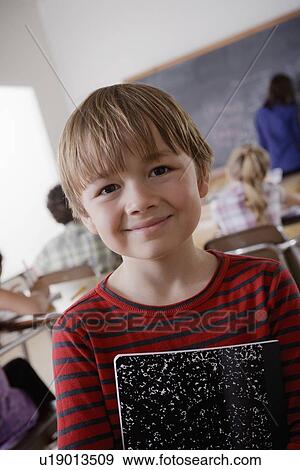 Portrait of schoolboy holding notebook View Large Photo Image Stock Photo - Portrait of schoolboy holding notebook. Fotosearch