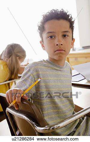 Picture - Portrait of schoolboy in classroom. Fotosearch