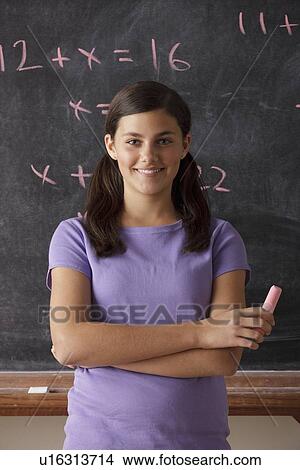 Portrait of schoolgirl (12-13) standing in front of blackboard during math classes View Large Photo Image Picture - Portrait of schoolgirl (12-13) standing in front of blackboard during math classes. Fotosearch