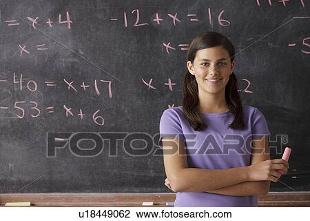 Portrait of schoolgirl (12-13) standing in front of blackboard during math classes View Large Photo Image Stock Image - Portrait of schoolgirl (12-13) standing in front of blackboard during math classes. Fotosearch