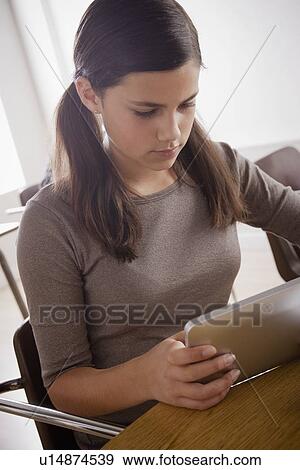 Stock Photo - Portrait of schoolgirl (12-13) with digital tablet. Fotosearch