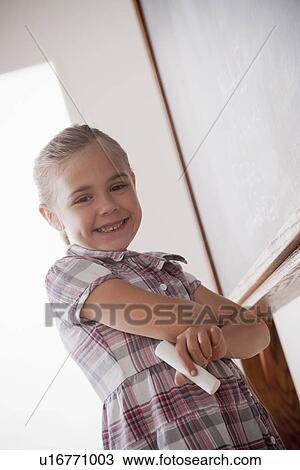 Portrait of schoolgirl holding chalk View Large Photo Image Stock Image - Portrait of schoolgirl holding chalk. Fotosearch