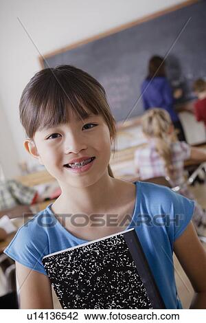 Portrait of schoolgirl holding notebook View Large Photo Image Stock Image - Portrait of schoolgirl holding notebook. Fotosearch