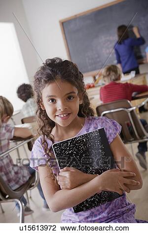 Portrait of schoolgirl holding notebook View Large Photo Image Stock Image - Portrait of schoolgirl holding notebook. Fotosearch