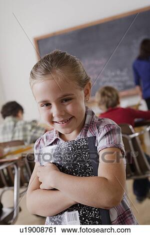 Portrait of schoolgirl holding notebook View Large Photo Image Stock Image - Portrait of schoolgirl holding notebook. Fotosearch
