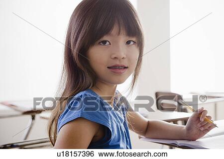 Portrait of schoolgirl holding pencil View Large Photo Image Stock Photograph - Portrait of schoolgirl holding pencil. Fotosearch